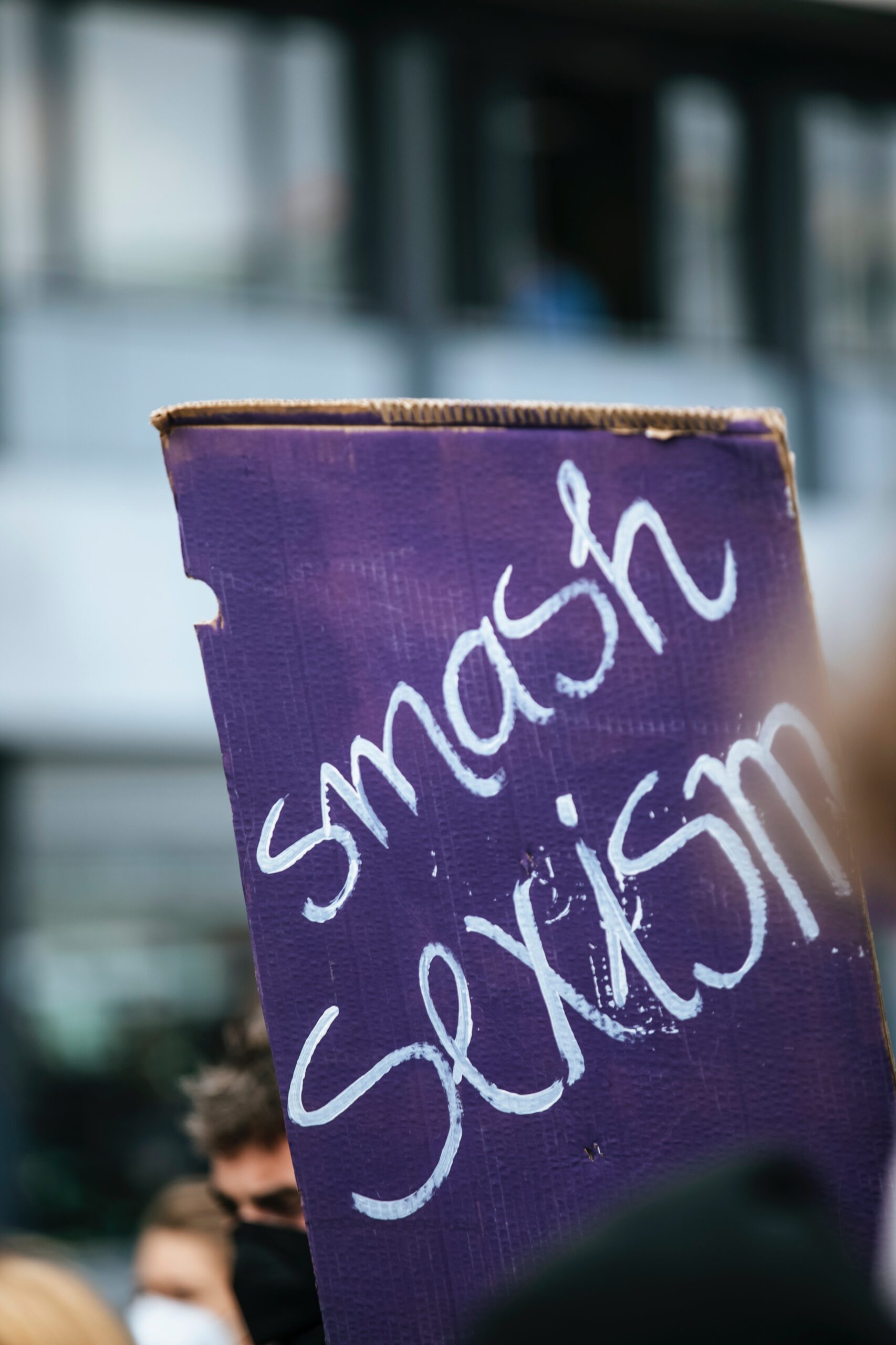 purple protest sign with the words smash sexism written